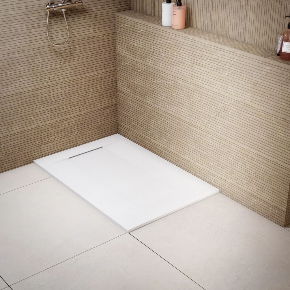 Lifestyle image of the Onyx Zeus Plus White Stone Effect 1200mm x 800mm Shower Tray installed in a wet room corner